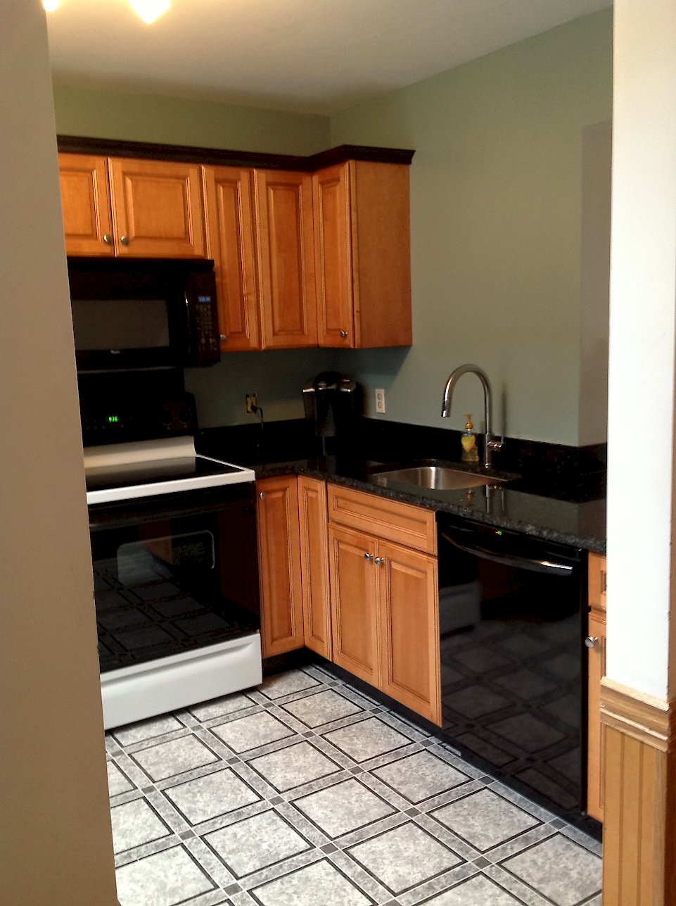 Dark crown molding and toe-kicks compliment the lighter cabinetry.
