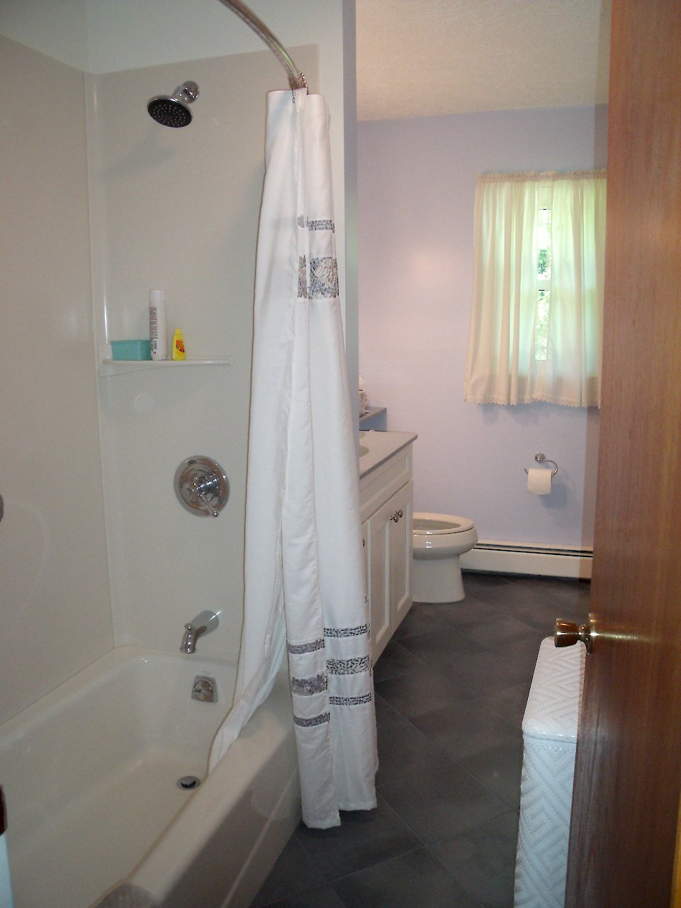 View of the shower/tub coming into the bathroom.